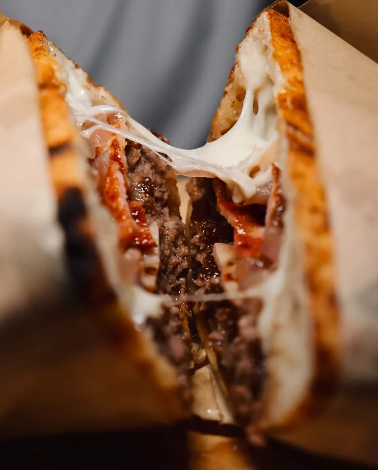 Close-up of a freshly griddled stuffed sandwich with melted cheese pull and seasoned beef